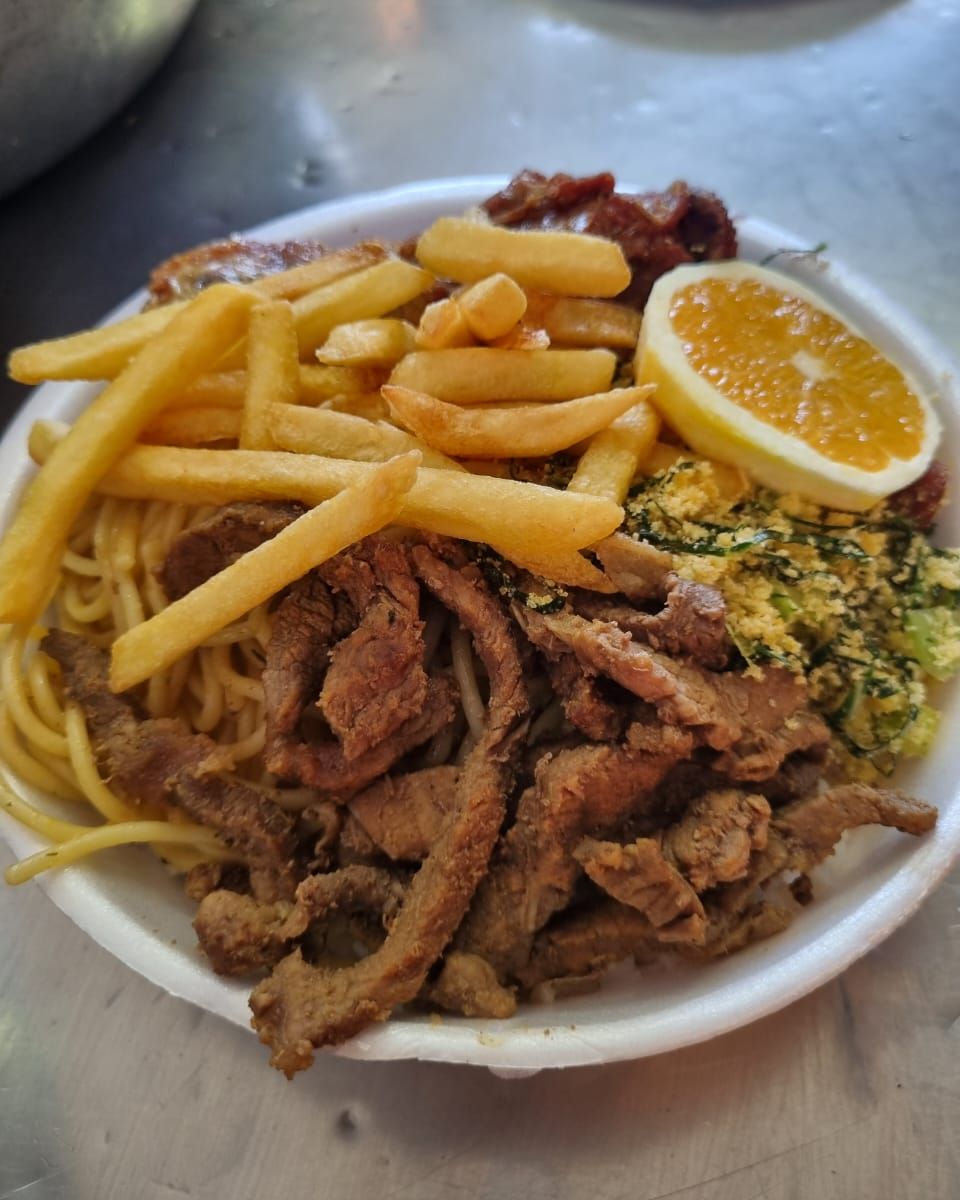 Prato com arroz, feijão, batata frita, macarrão alho e óleo, tiras de carne bovina, frango frito, laranja, farofa de couve